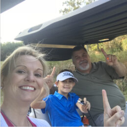 A family out playing golf taking a selfie after a hole in one