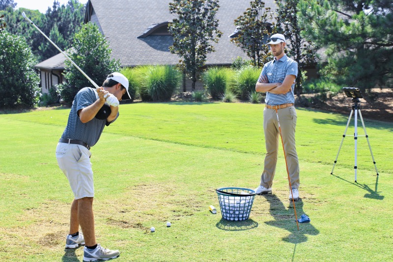 Golf coach watching student during a private lesson